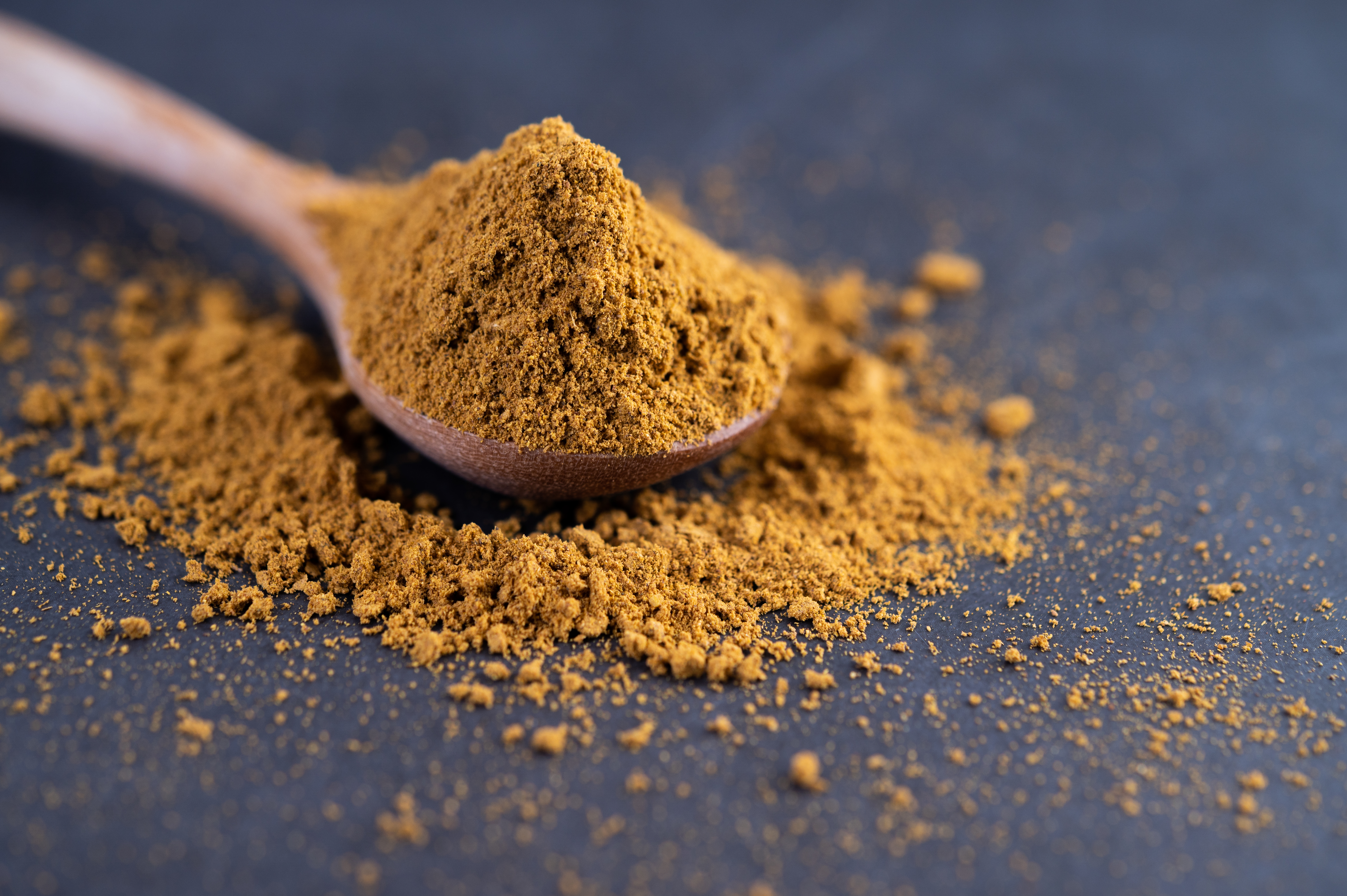 Spices are placed in a spoon and placed on the cement ground. Selective focus